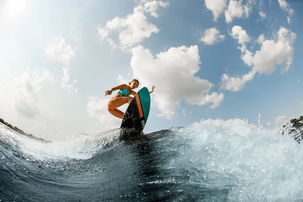 Mujer de la energía que se divierte wakesurfing en el tablero en la ola del río contra el cielo azul —  Fotos de Stock