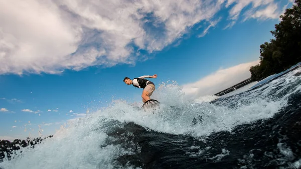 Aktiver Mann mit amputierter Hand reitet auf Wakeboard auf der Welle — Stockfoto