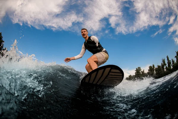 Vue du bas d'un homme manchot qui se réveille sur la planche le long de la vague — Photo