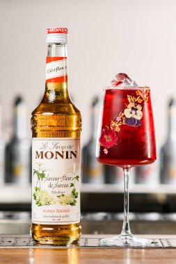 UKRAINE, KYIV - 12 Mart 2021: Saveur fleur de sureau şurubu ve bar tezgahında soğuk kırmızı kokteyl şişesi