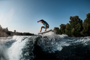 Aktif adam su sporlarıyla ilgileniyor. Dalgaların üzerinde uyanmak ve zıplamak gibi.