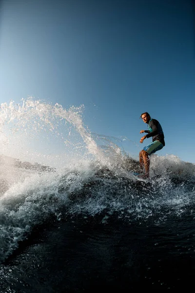 Homme habilement monter vague sur le wakesurf sur le fond du ciel bleu — Photo