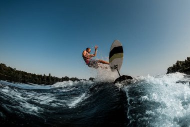 İnsan binicisi folyodan damlayan nehir dalgasına düşer
