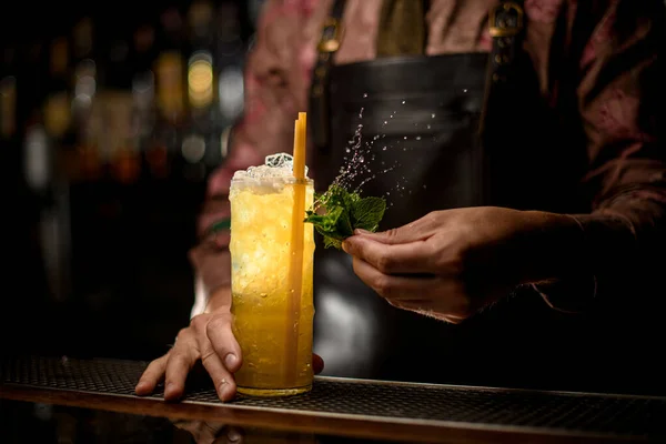 Wspaniały widok na szklankę pełną lodu i koktajlu ze słomkami do picia i męską dłonią z mokrymi liśćmi mięty — Zdjęcie stockowe