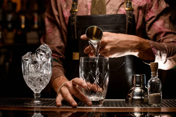 Genomskinliga glas i ett av vilka människobartenderns hand dricker — Stockfoto