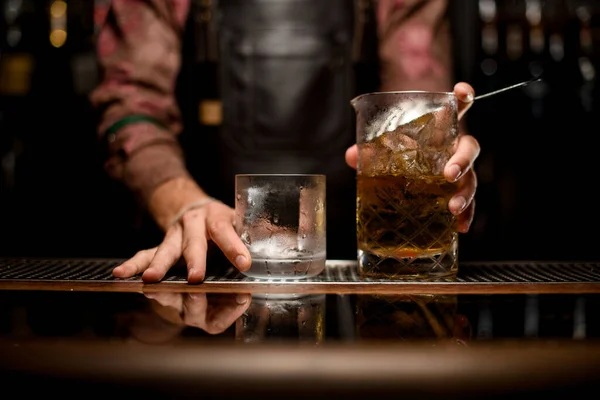Vidrio transparente vacío y taza de mezcla con bebida fría en el mostrador de bar — Foto de Stock