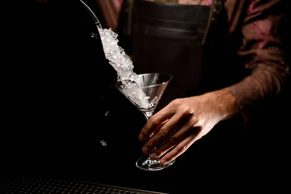 Transparentes Martini-Glas in der Hand des Menschen, in das zerstoßenes Eis gegossen wird — Stockfoto