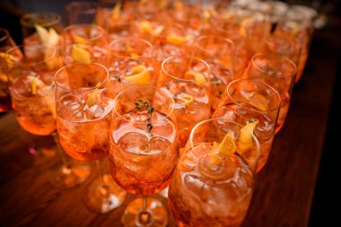 Buz küpleri ve portakal dilimleriyle aperol spreyli kokteyl bardaklarına odaklan.