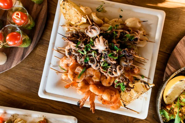 Vista superior de camarones y pulpos aperitivos de mariscos en el plato en la mesa — Foto de Stock