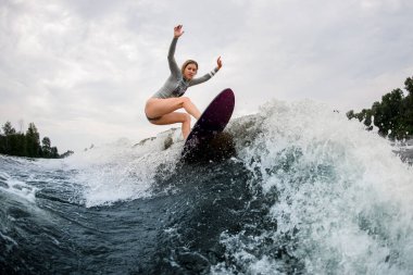 # Gri dalgıç kıyafetli aktif bir kadın # # Dalgaların üzerinde süzülen dalgalara biniyor #