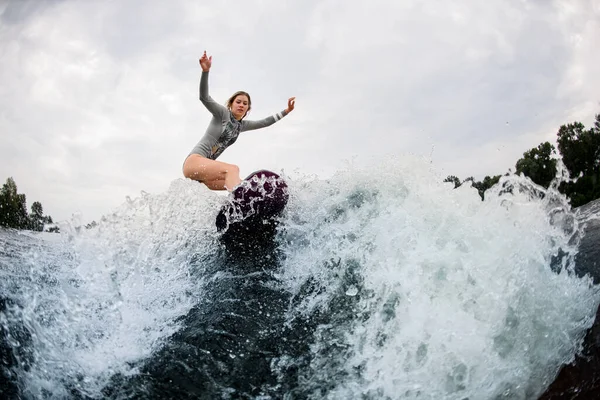 Belle vue sur la vague éclaboussante et la femme active sur wakesurf descend dessus — Photo