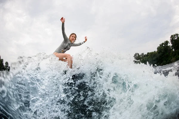 Magnífica vista en salpicadura ola y mujer activa en wakesurf paseos hacia abajo en él —  Fotos de Stock