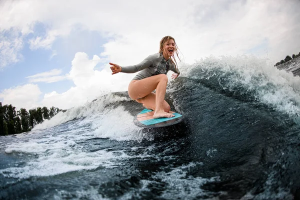 Femme joyeuse descend la vague assis sur un wakeboard. Loisirs d'été — Photo