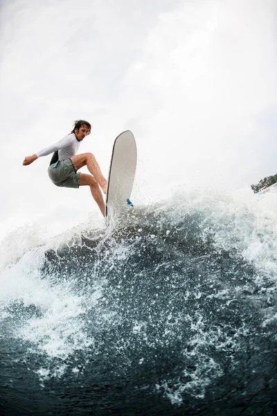Atlético cara ter diversão e saltos no onda no wakesurf bordo no verão dia. — Fotografia de Stock