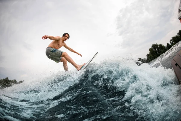 Energia esportiva homem balanceamento no wakesurf bordo em espirrar onda — Fotografia de Stock