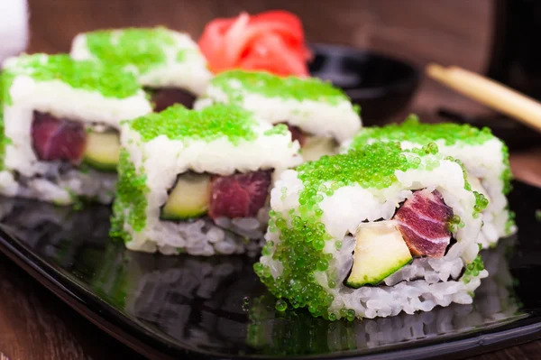 Sushi rulla uppsättningen i grön kaviar med ingefära, soja, handduk och ätpinnar — Stockfoto