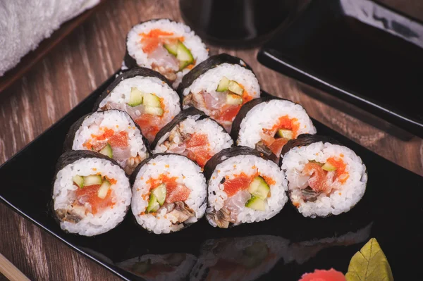 Assorti pește sushi rulou pe placă neagră — Fotografie, imagine de stoc