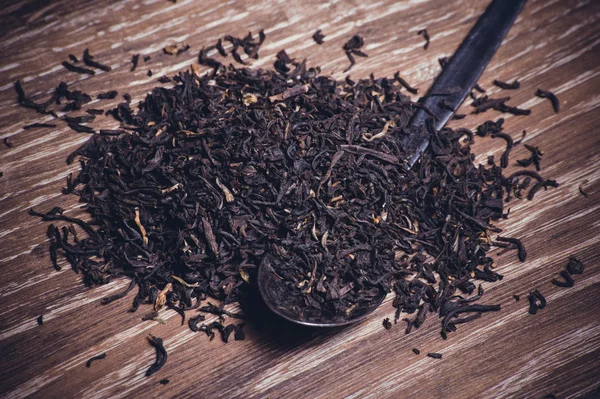 Té negro hojas secas en cuchara —  Fotos de Stock