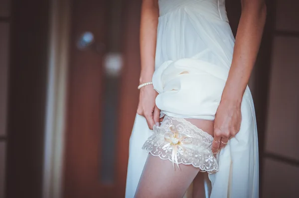 Sposa mettendo su giarrettiera bianca — Foto Stock