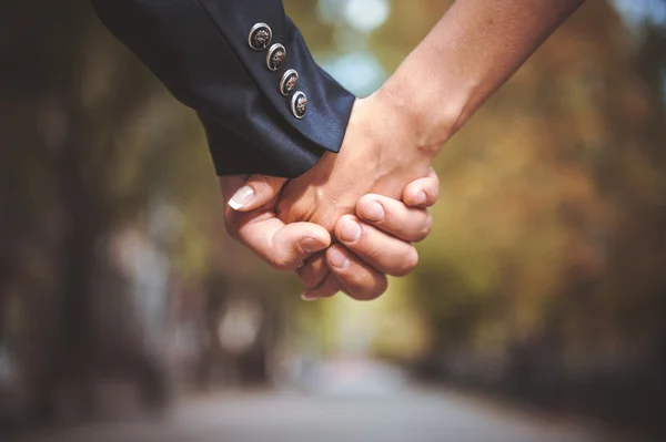 Par hålla hand tillsammans i park — Stockfoto