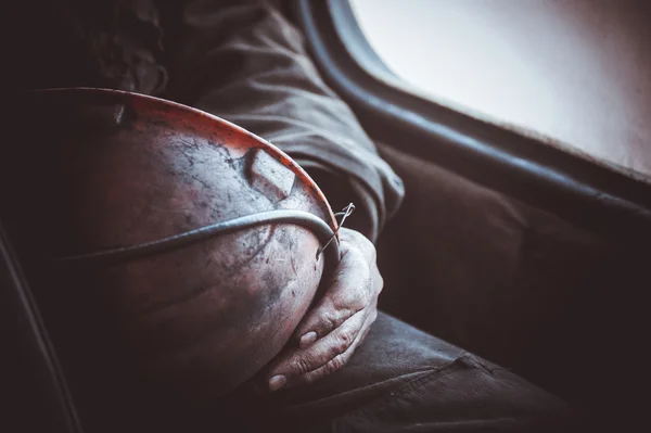 Durty hands of miner worker hold helmet — Stock Photo, Image