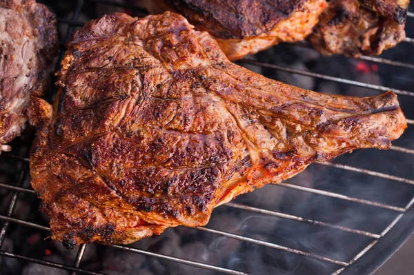 Bife grande carne com osso na grelha grelhando sobre o carvão de churrasco — Fotografia de Stock