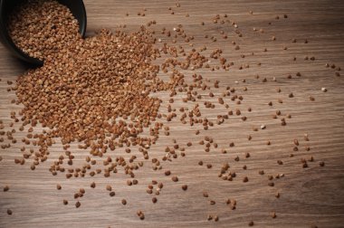 Ahşap masa arka plan üzerinde siyah bir kase gelen tutam buğday