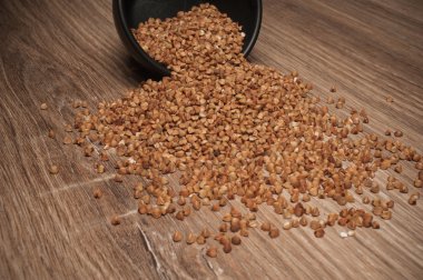 Ahşap masa arka plan üzerinde siyah bir kase gelen tutam buğday