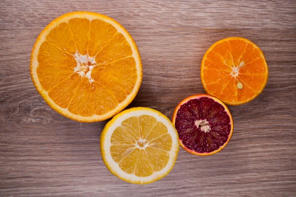 Sor szeletelt citrusfélék citrom, narancs, grapefruit, mandarin, fából készült háttér felett. Szemközti nézet. — Stock Fotó