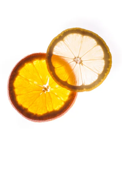 Slice of an orange and lemon  isolated on white background back lit — Stock Photo, Image