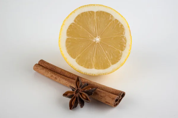 Canela, anis estrelado e limão sobre fundo branco — Fotografia de Stock