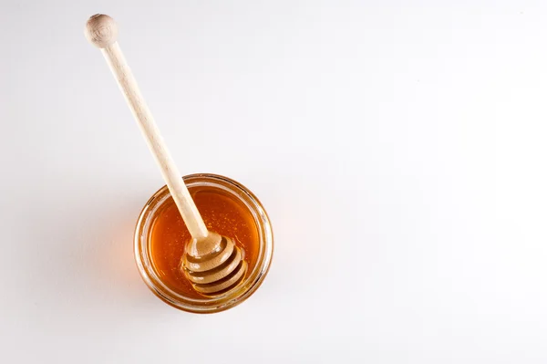 Glass can full of honey and wooden stick in it. top view — Stock Photo, Image