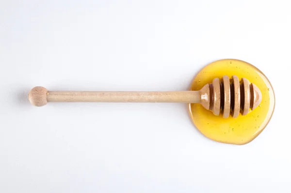 Miele che scende da un bastone di legno isolato su sfondo bianco — Foto Stock