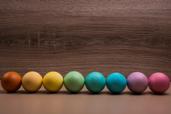 Fila di uova di Pasqua su sfondo di legno — Foto Stock