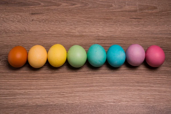 Easter eggs row on wooden background — Stock Photo, Image