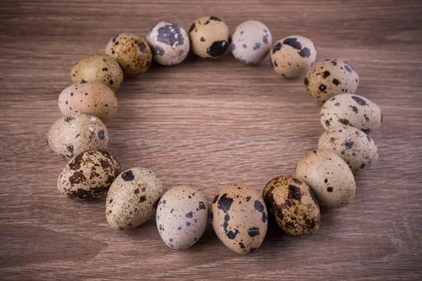 Quail eggs circle on wooden background — Stock Photo, Image