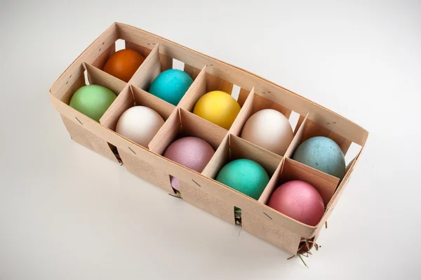 Easter colored eggs in wooden box isolated — Stock Photo, Image