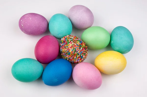 Ovos de páscoa coloridos e um coberto com polvilhas isoladas — Fotografia de Stock