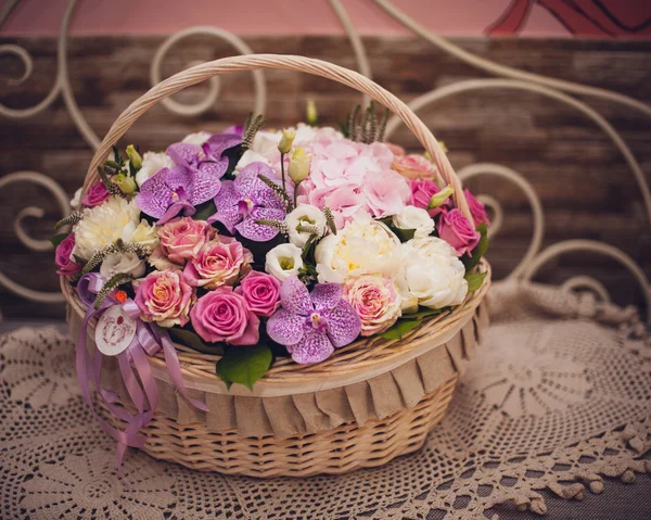 Hermoso ramo de flores de color rosa en la cesta en la mesa decorada —  Fotos de Stock