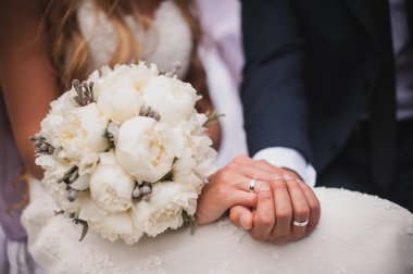 Gelin ve damat gelin buketi taşıyor. 