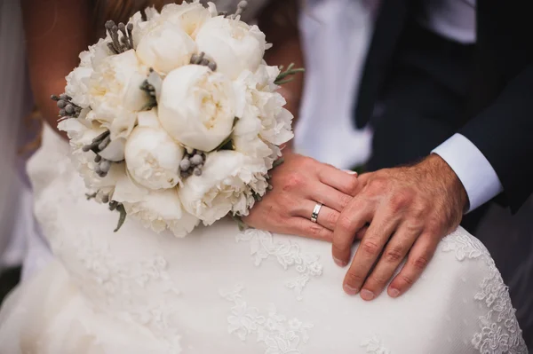Hände von Braut und Bräutigam mit Brautstrauß. — Stockfoto