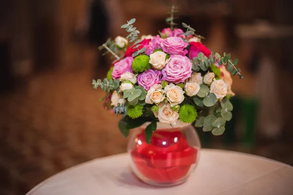 Beau bouquet de fleurs lumineuses en vase en verre, sur la table — Photo