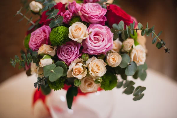 テーブルの上のガラスの花瓶で明るい花の美しい花束 — ストック写真