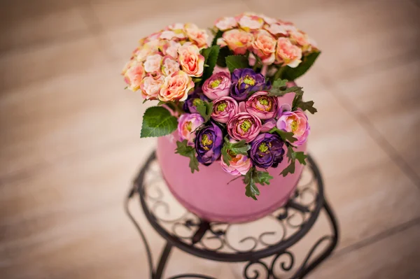 Mooi boeket van heldere bloemen in mand op glazen tafel — Stockfoto