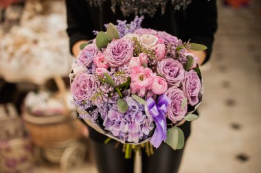 bir buket çiçek tutan kadının el