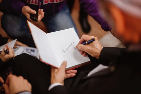 Auteur ondertekening handtekening in eigen boek — Stockfoto