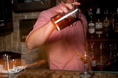 Bir cam içine kokteyl dökme barmen