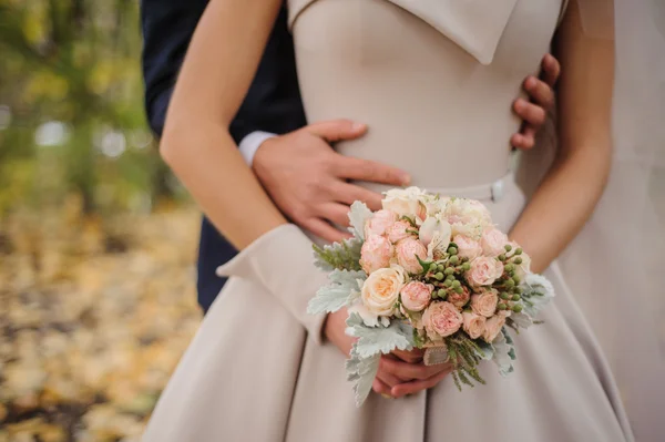 Bruden och brudgummen håller bukett — Stockfoto