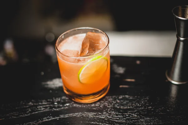 Апельсиновий коктейль прикрашений скибочками лайма — стокове фото