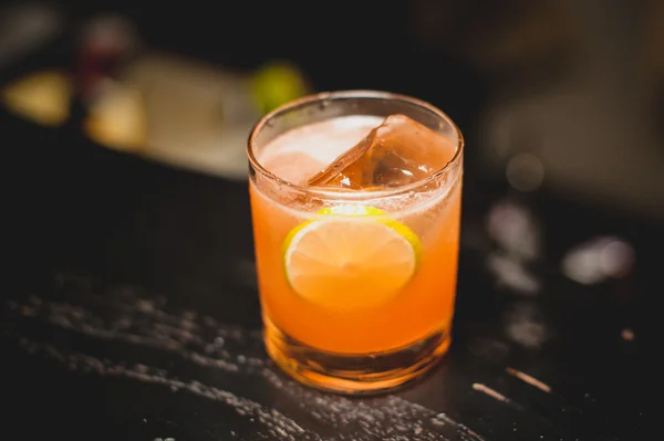 Orange cocktail decorated with lime slice — Stock Photo, Image